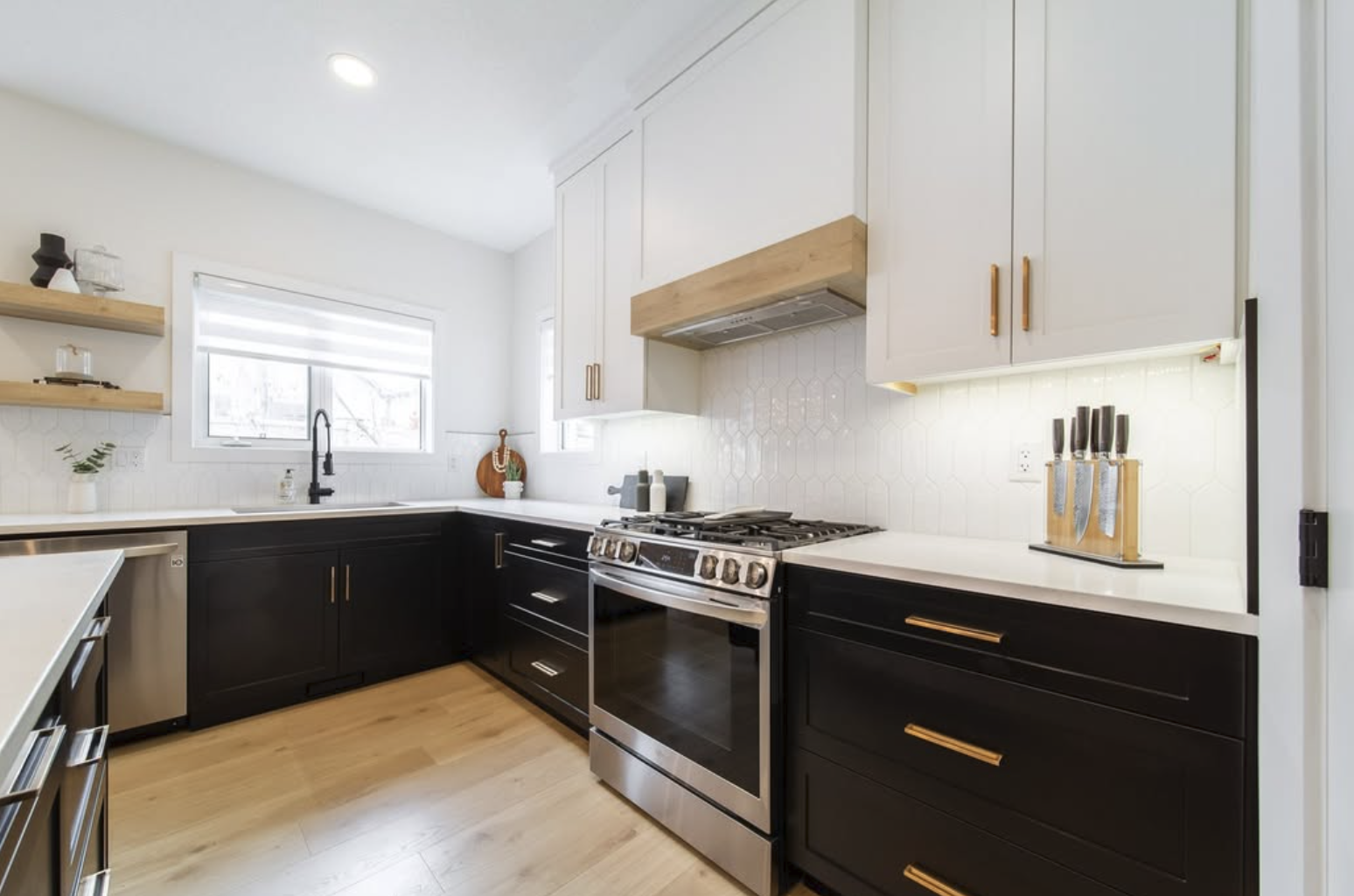 Renovated kitchen with black cabinetry and brass hardware